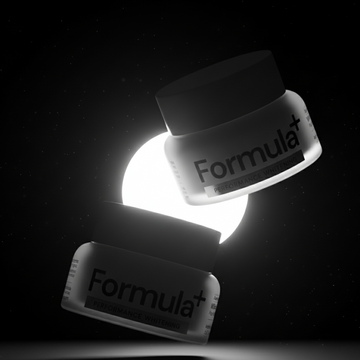 Two jars of Formula+ whitening powder on a dark background with a spotlight effect.